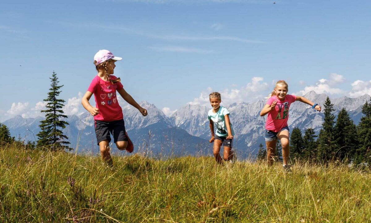Kinder laufen auf Bergwiese